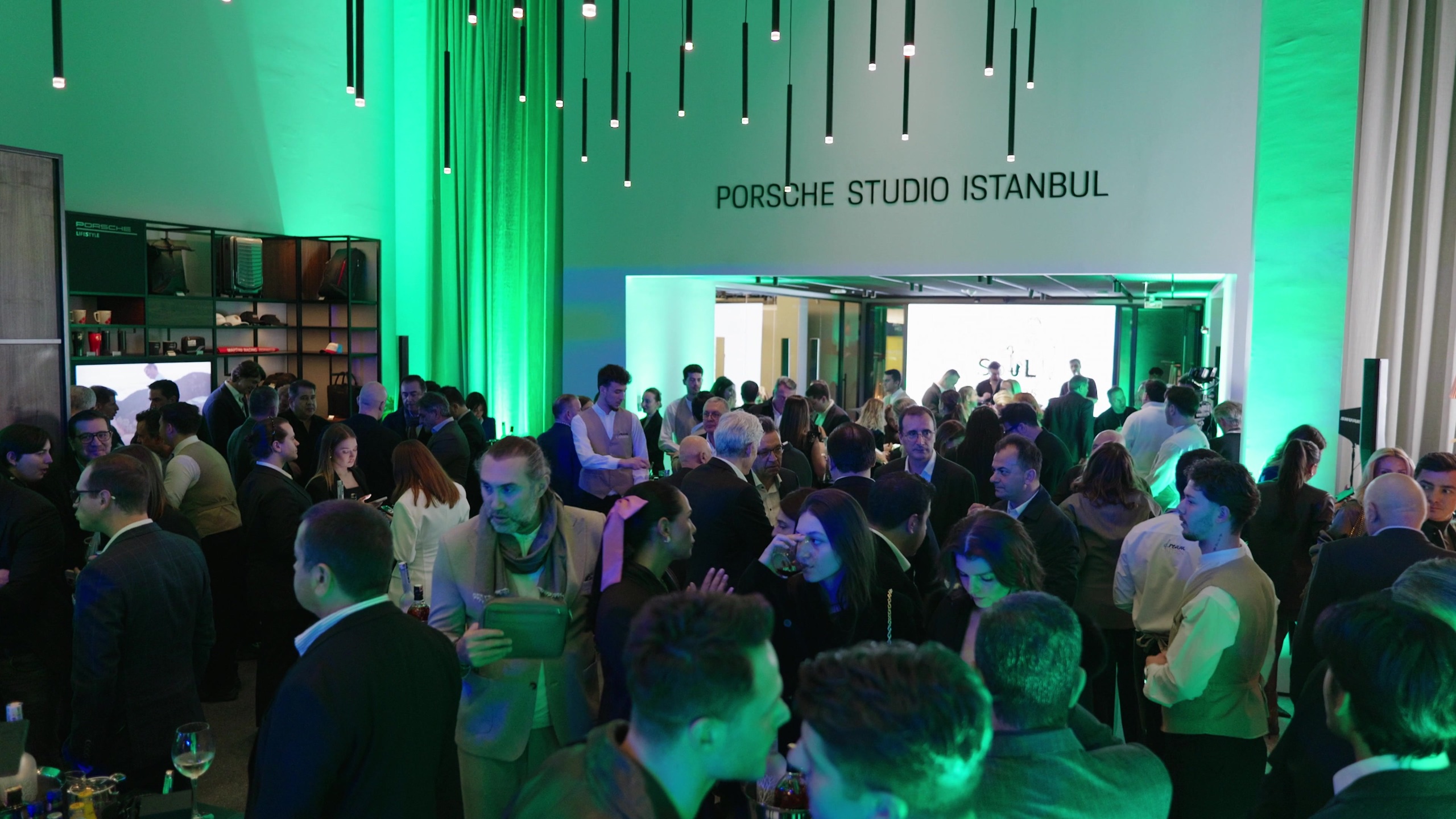 Crowd filling the studio under green evening light