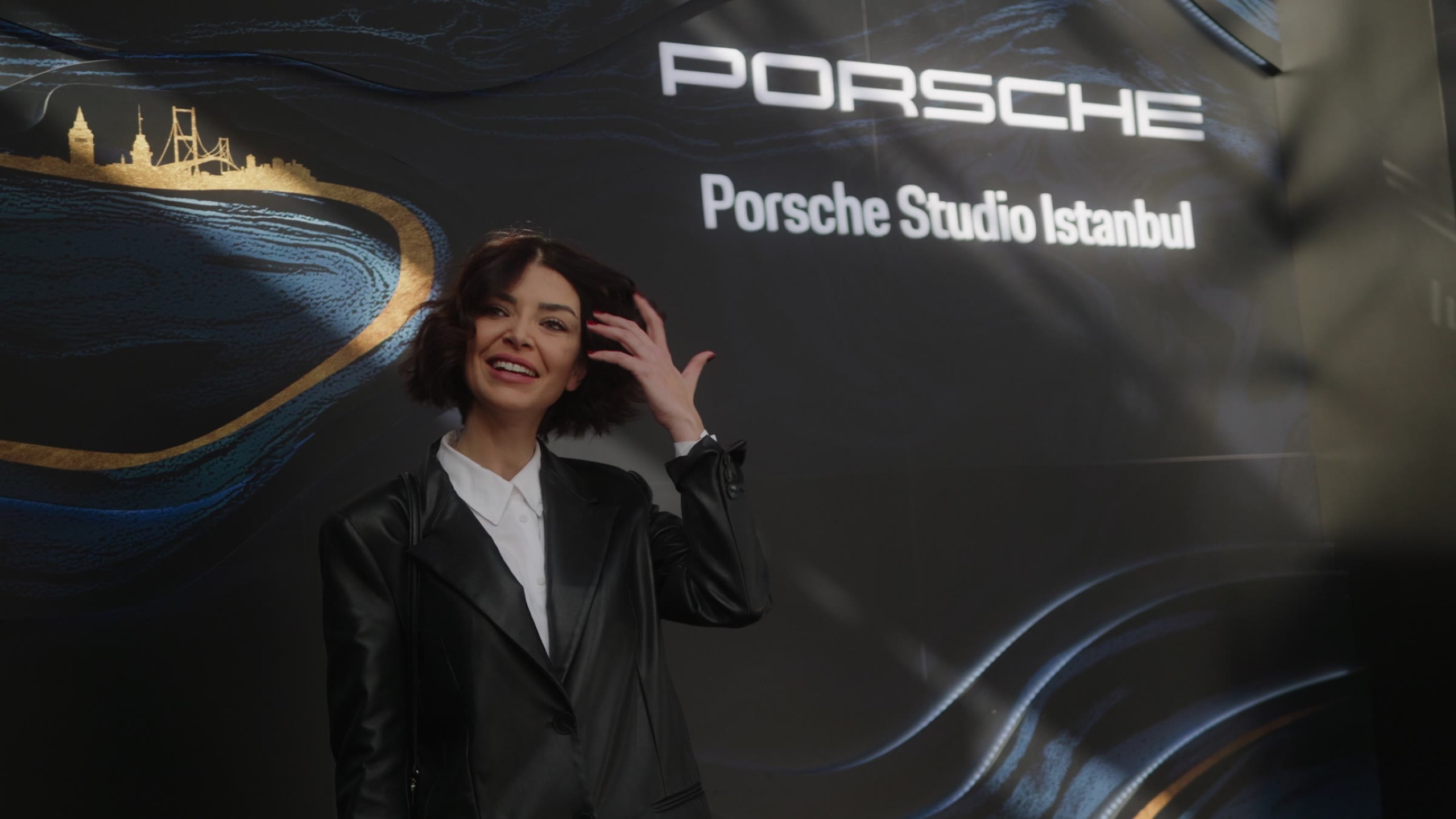 Guest posing in front of the Porsche Studio Istanbul backdrop
