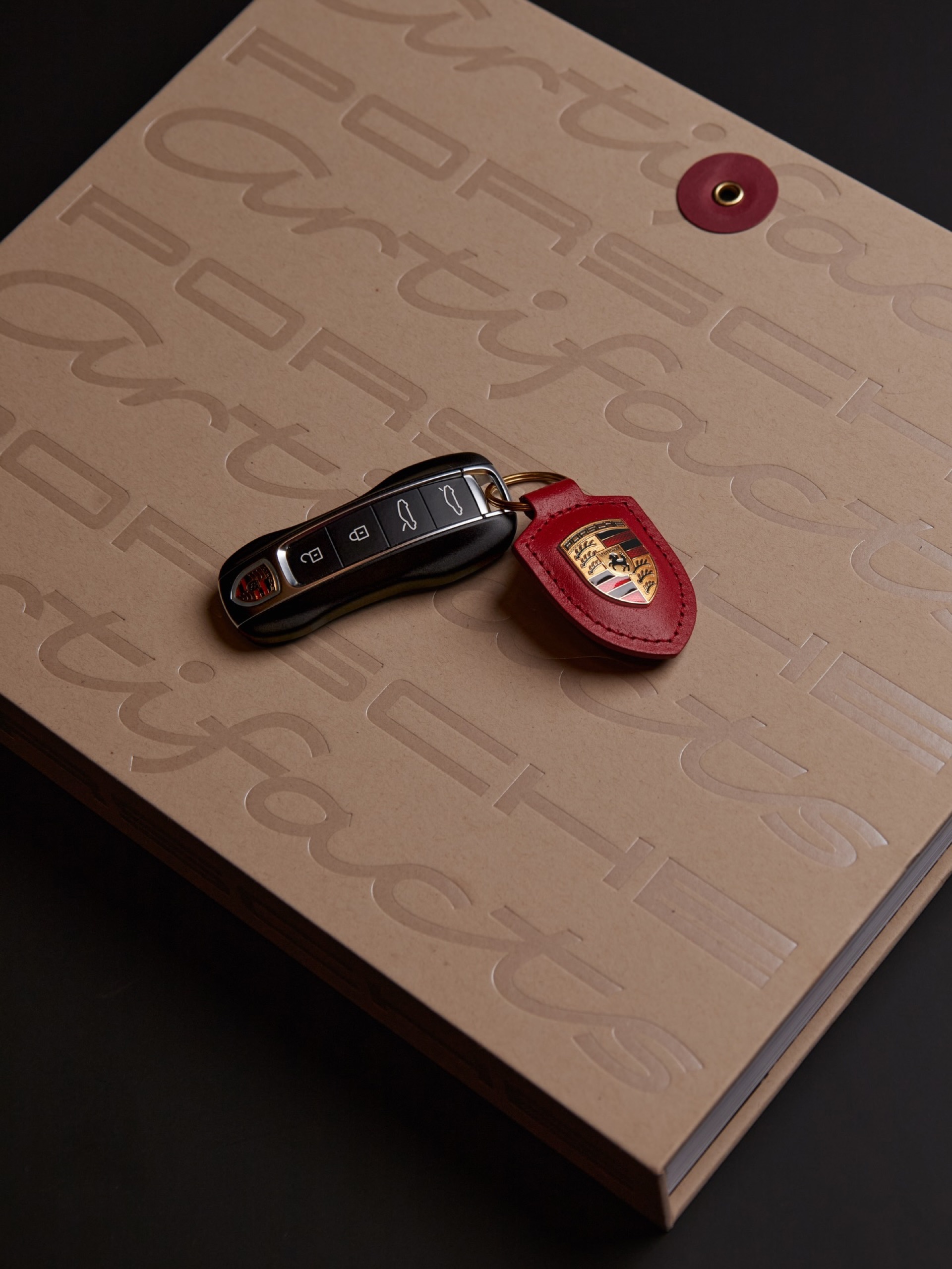 Porsche key resting on an embossed envelope