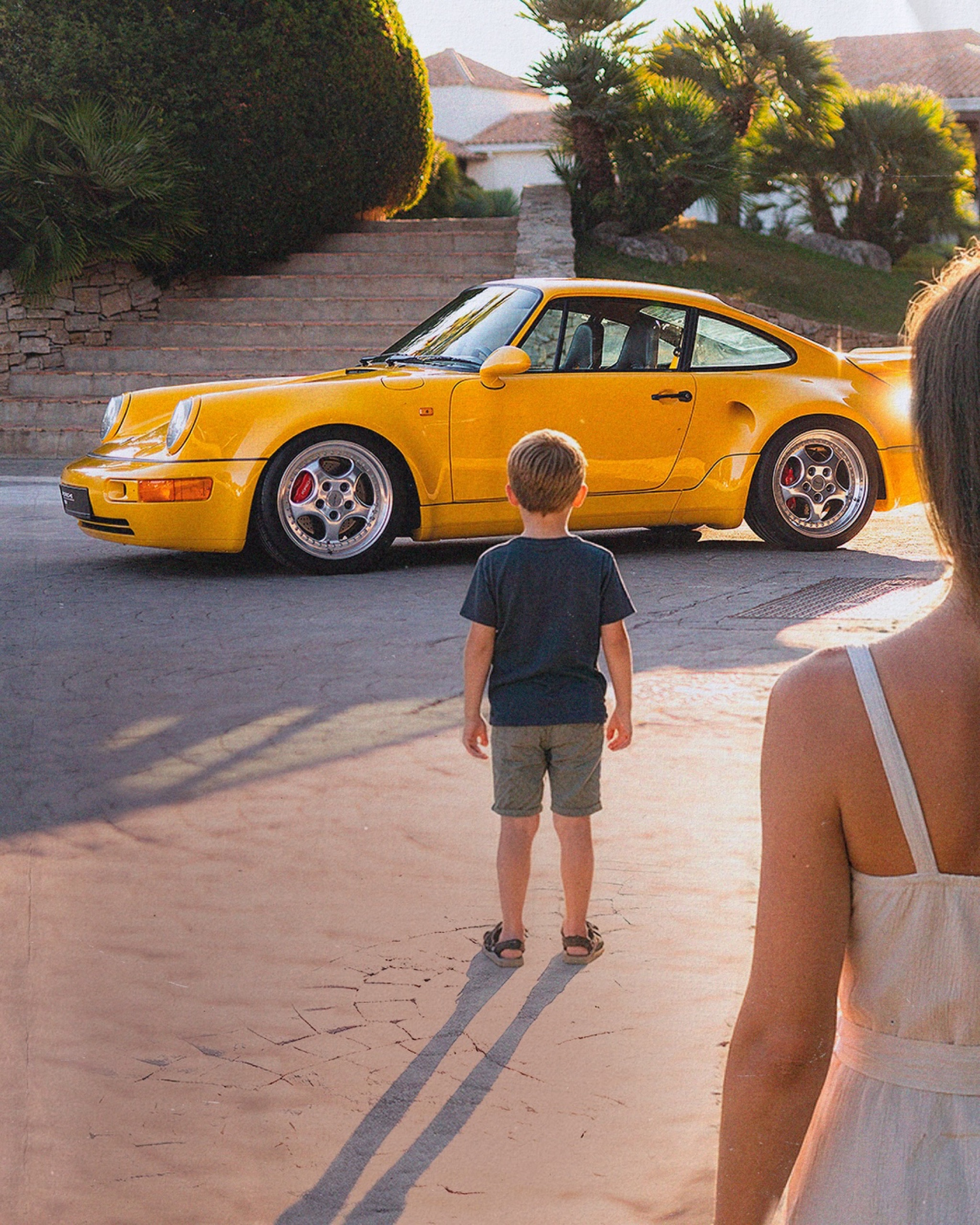 A child looking at a yellow classic 911
