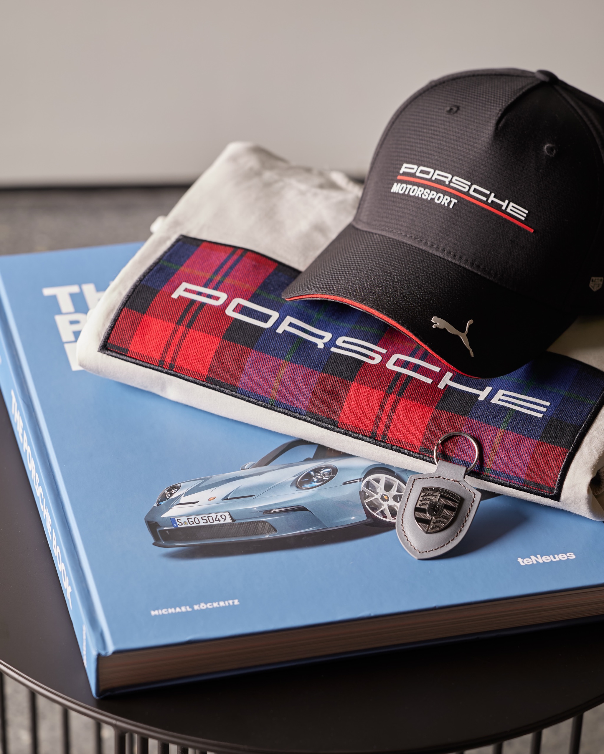 Porsche book, cap and collectibles styled on a blue cover