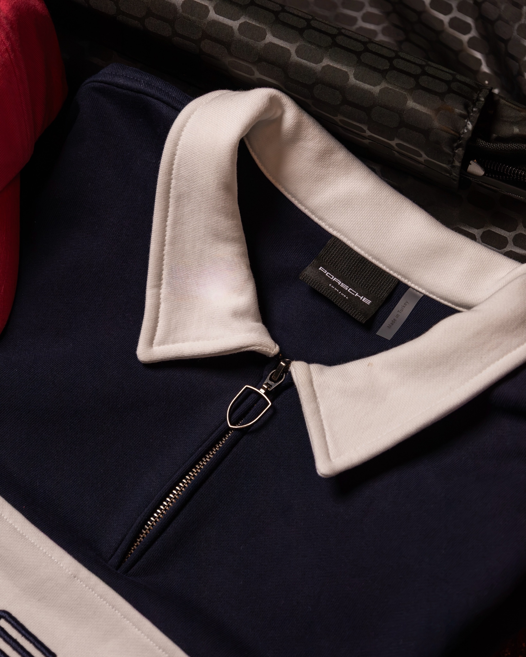 Lifestyle collection styled as a flat lay with cap, polo and bottle, 3