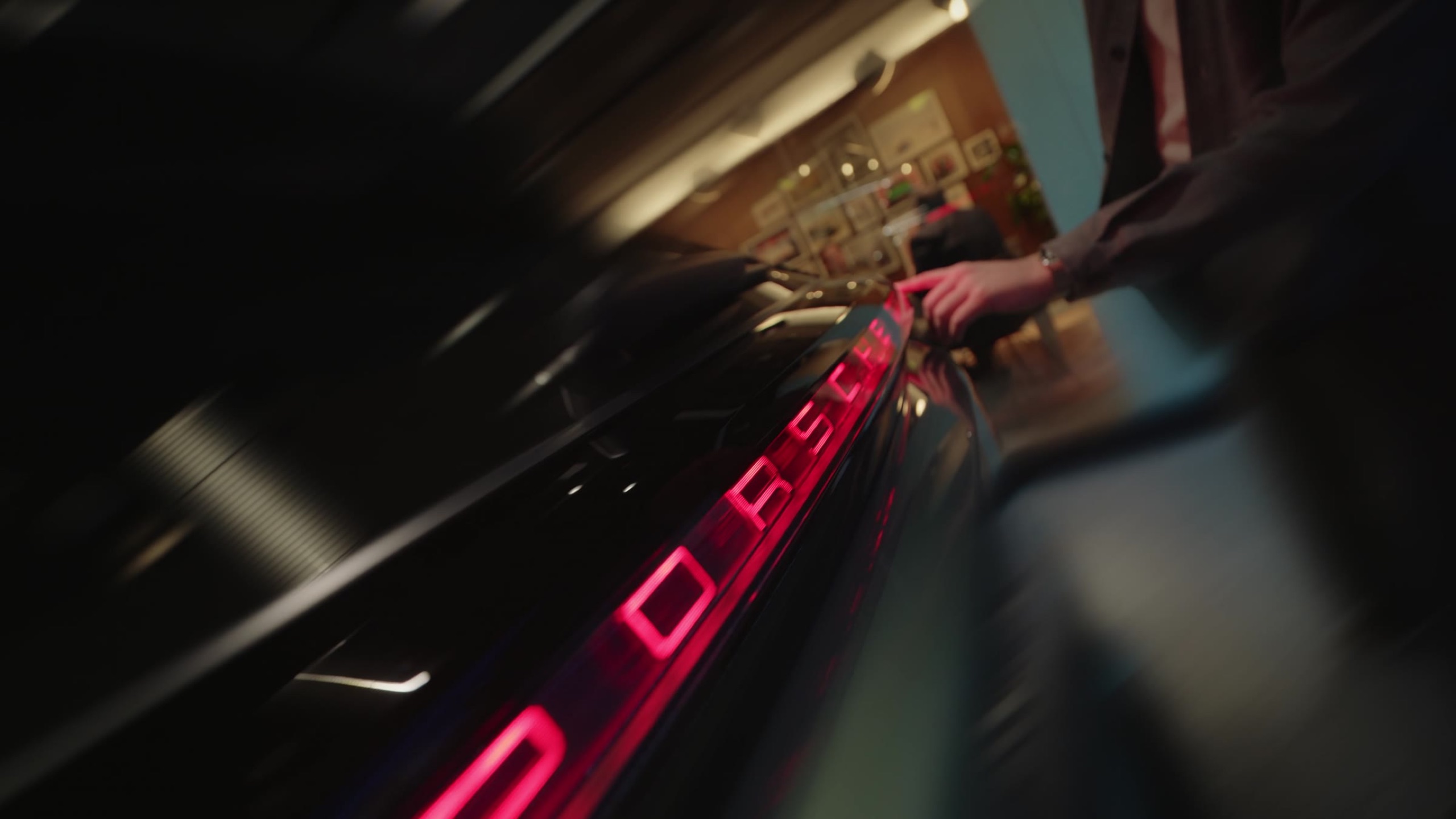 Illuminated Porsche lettering streaking past in motion